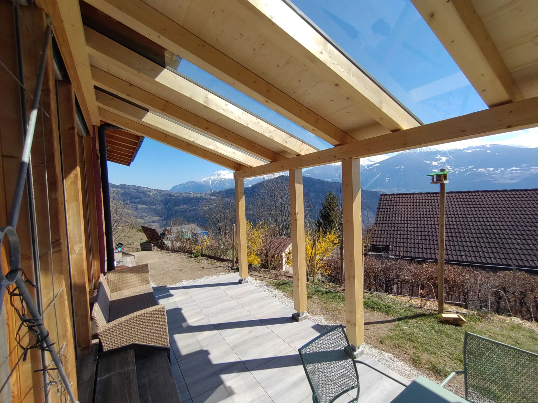 Couvert de terrasse en bois avec vitrage, vue sur les montagnes